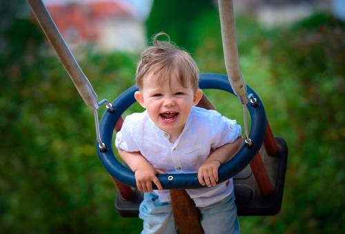 Uśmiechnięte dziecko na huśtawce